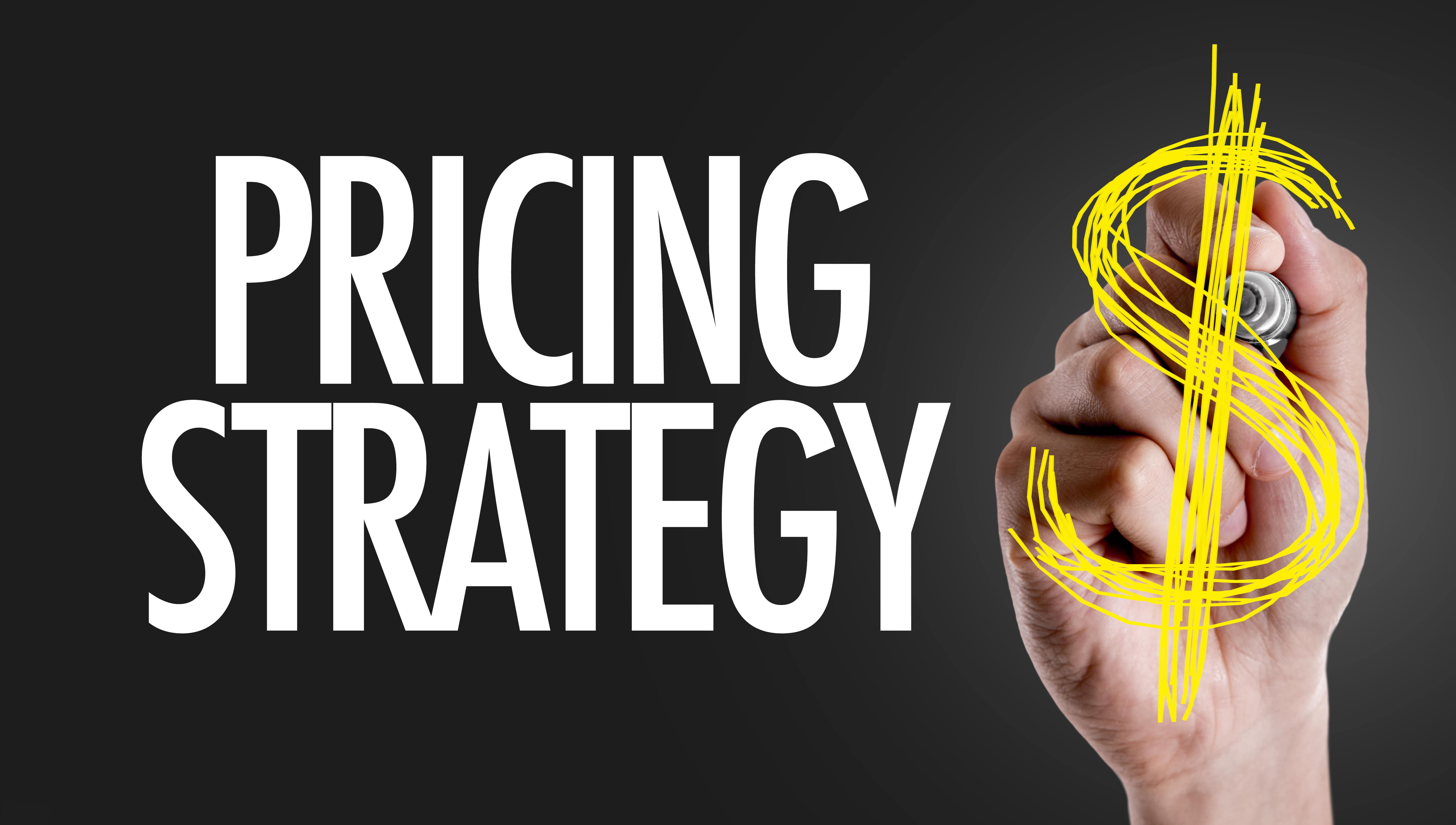 The words “Pricing Strategy” are written in bold white letters on a dark background. A hand draws a large yellow dollar sign with a marker, emphasizing financial planning and strategy.