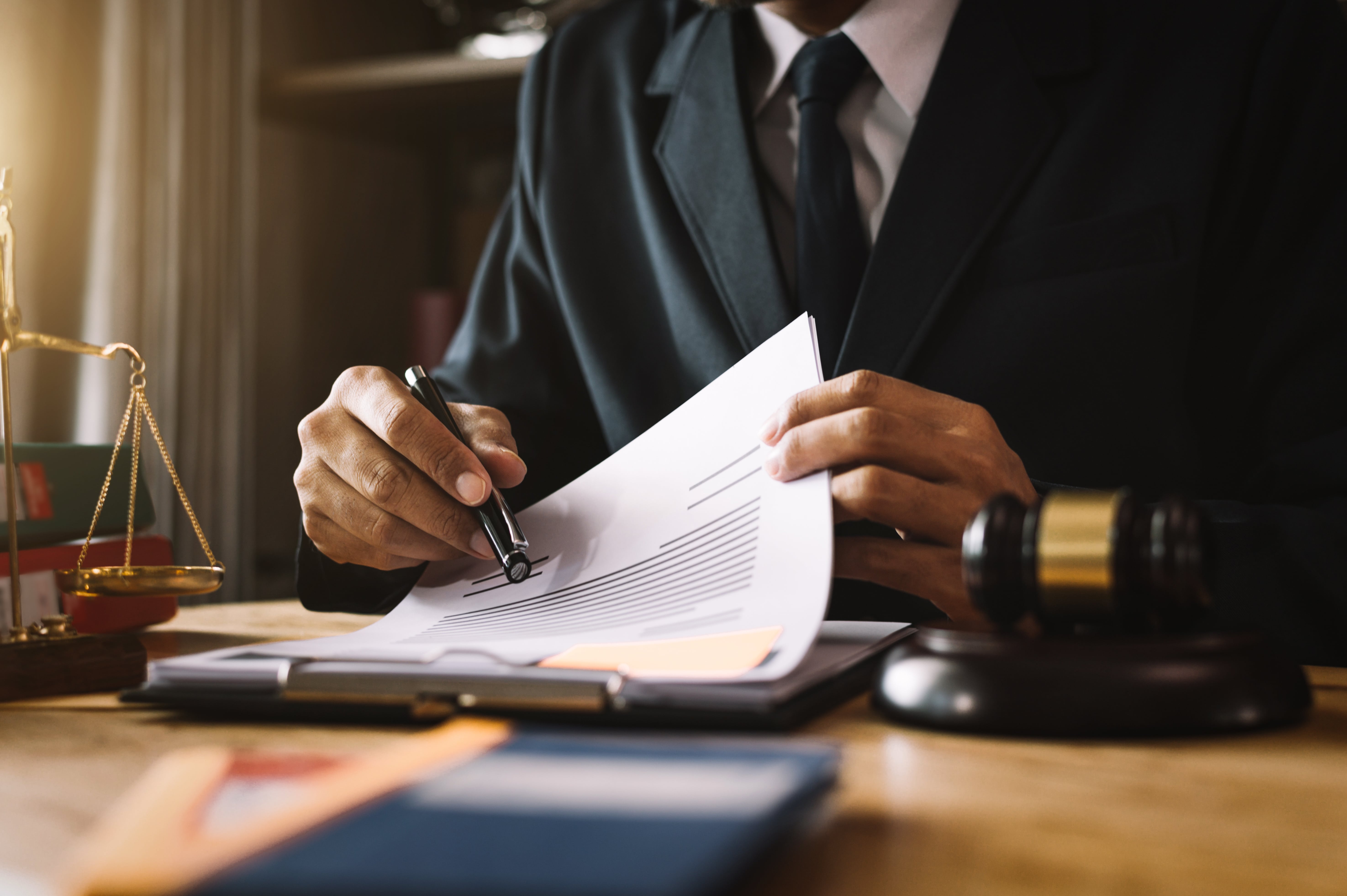 A lawyer in a suit reviewing legal documents with a gavel on the desk, representing legal compliance in Florida lease agreements.