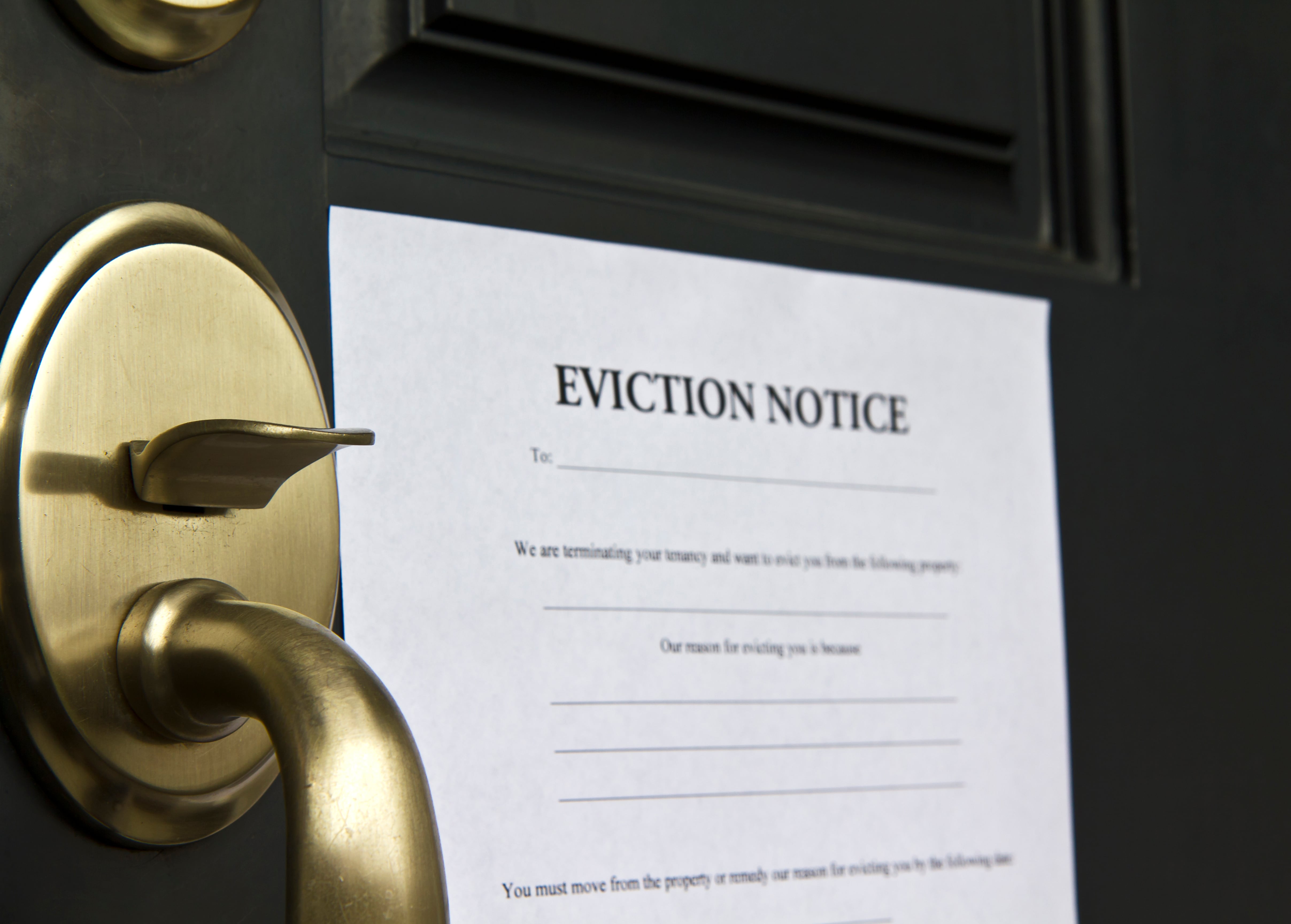 An eviction notice attached to a front door, emphasizing legal actions in tenancy.