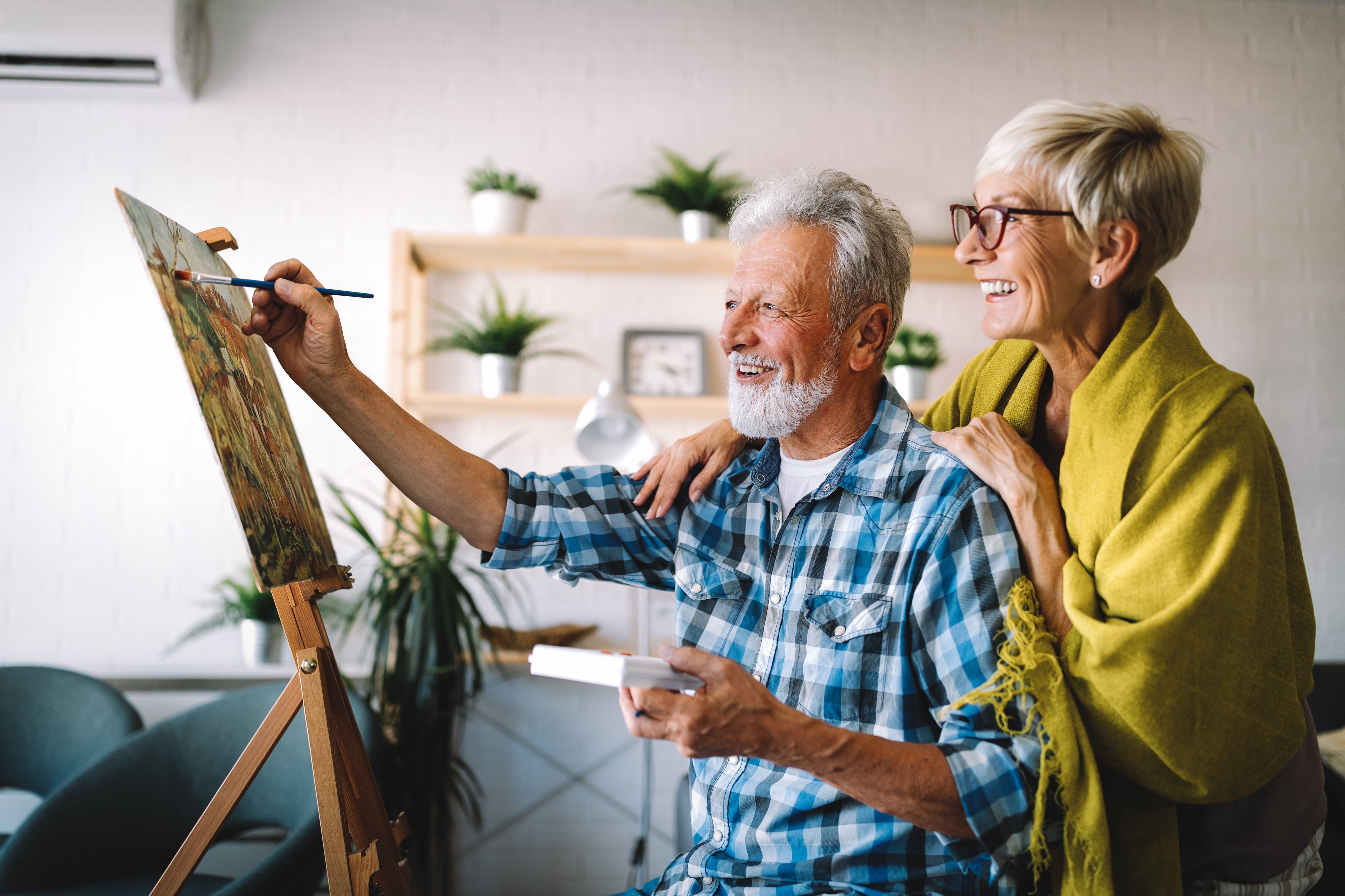 A happy senior couple enjoying painting together, symbolizing the benefits of stress-free property management for landlords.