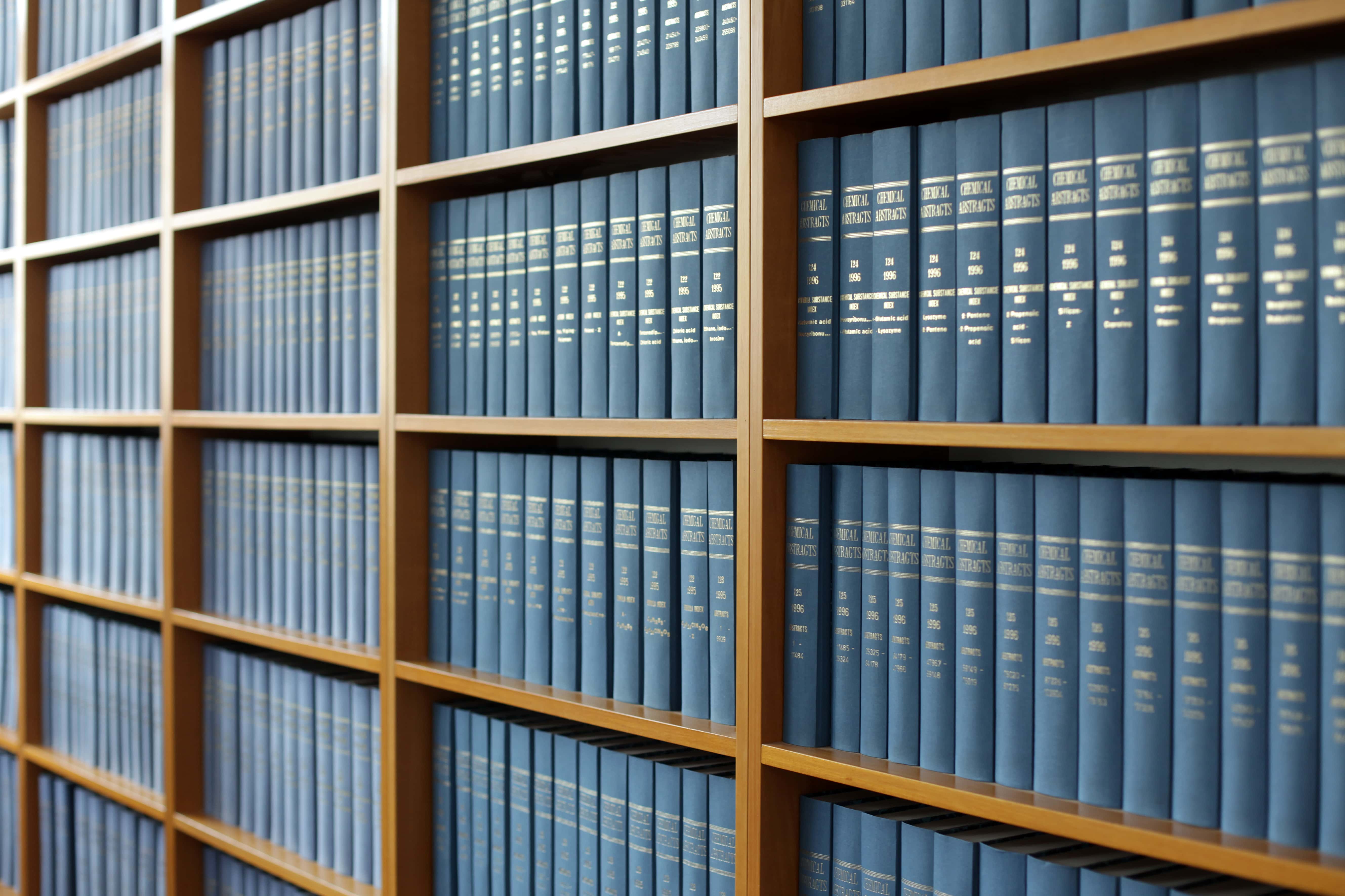 A bookshelf filled with blue legal books, representing property management laws and regulations.