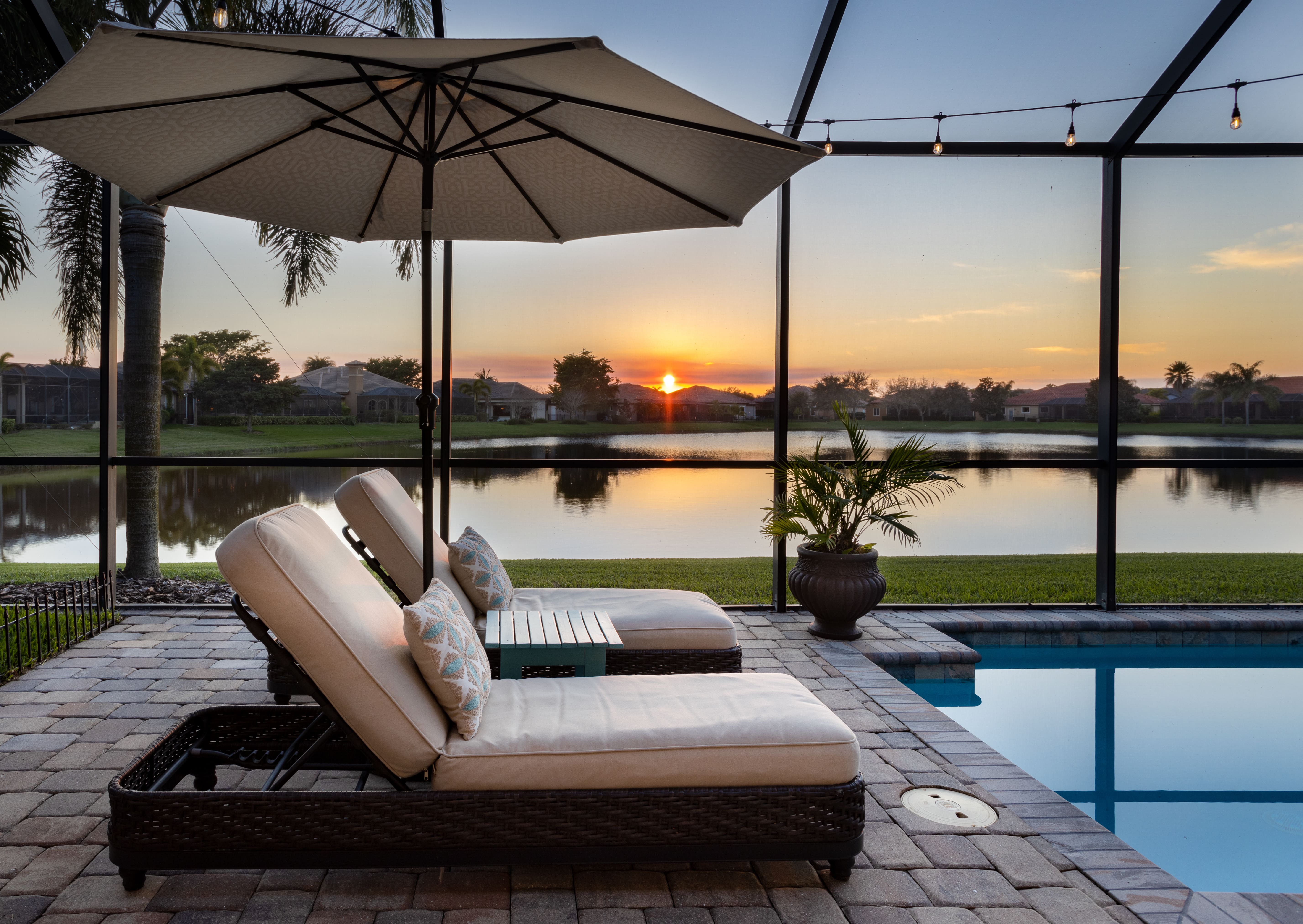 A scenic backyard with a pool and lake view at sunset, symbolizing the rewards of successful rental property management.