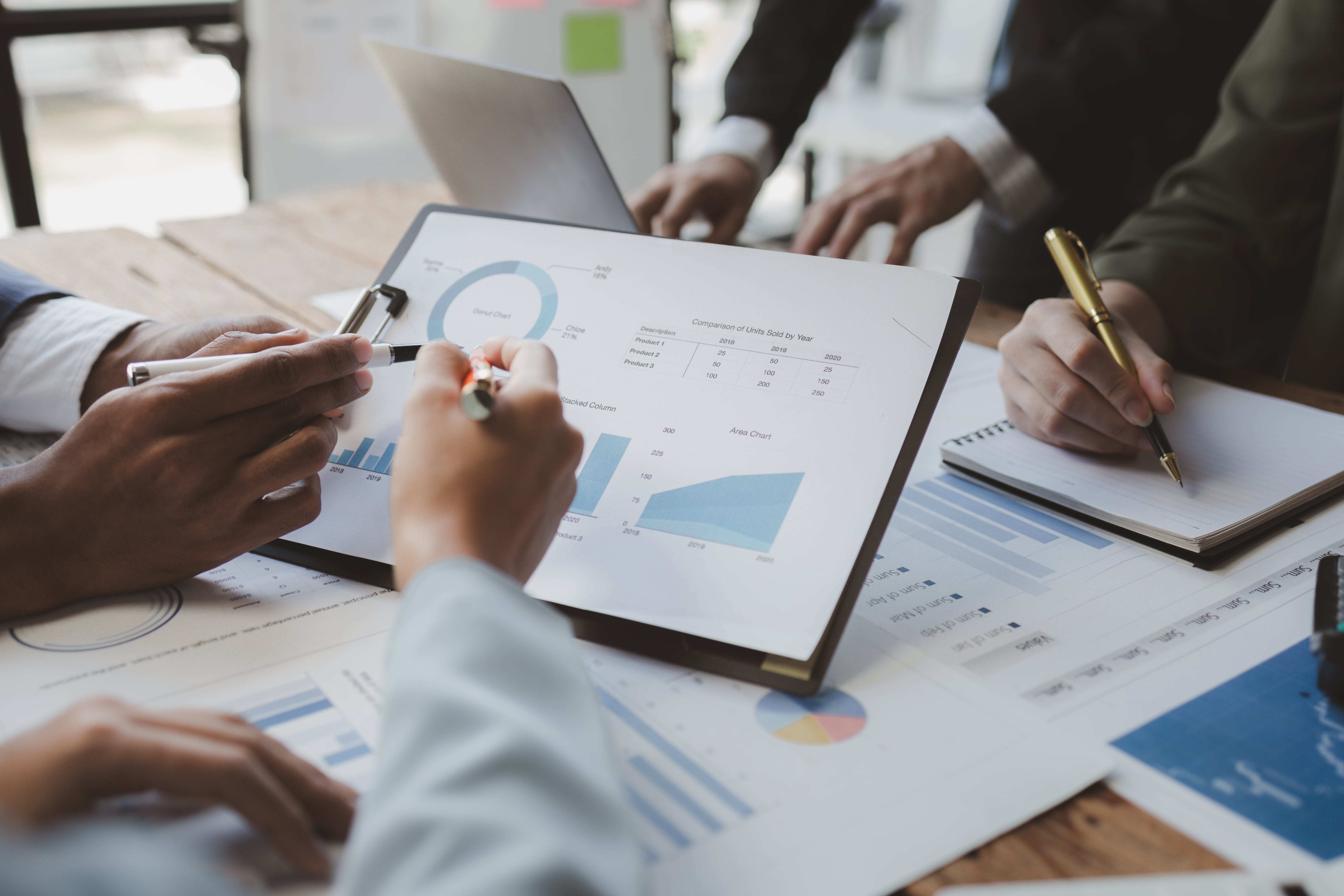 A business team reviewing financial reports with charts and graphs, representing the accounting and financial responsibilities of a property manager.