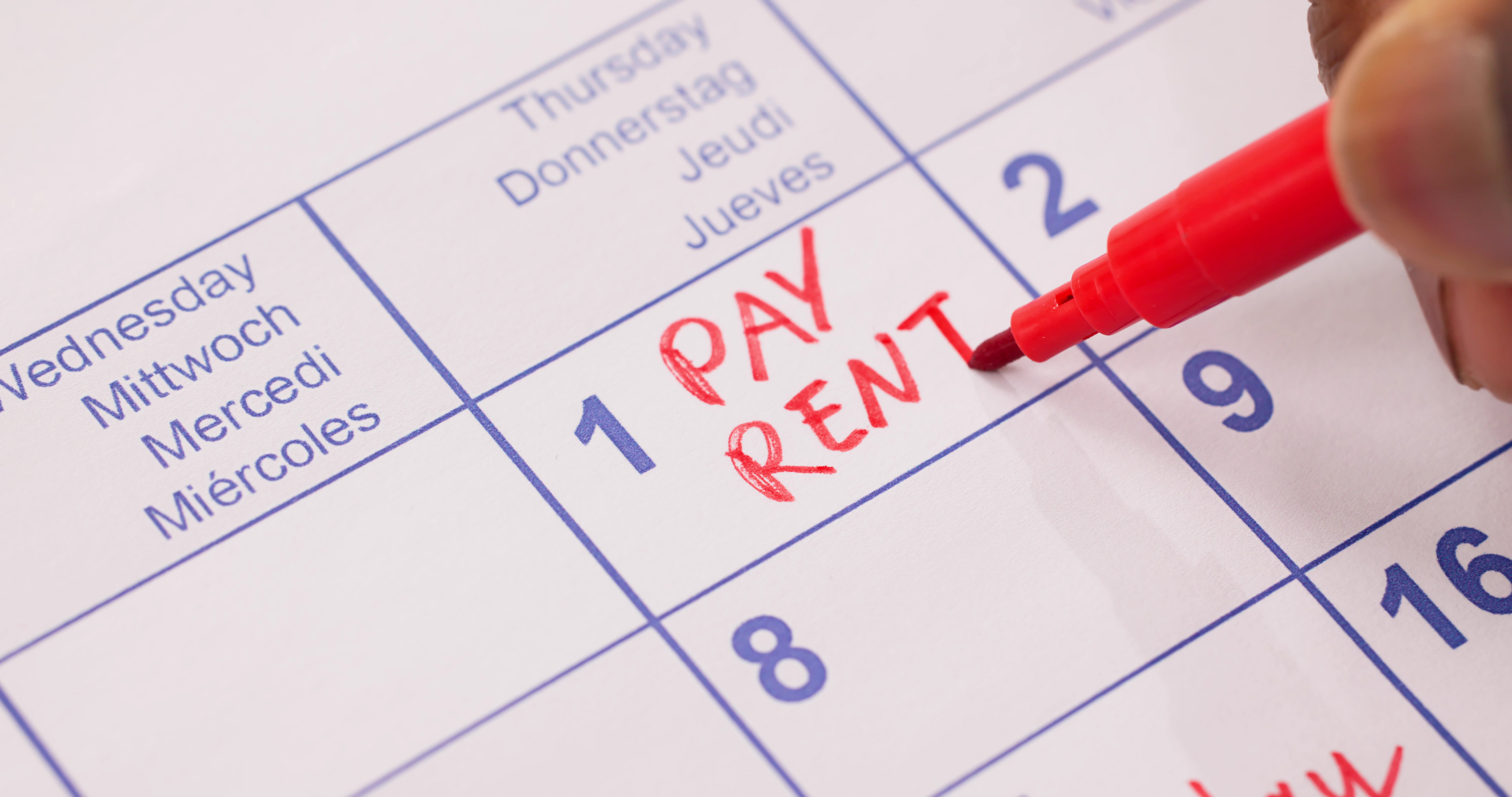 A calendar with the words “PAY RENT” written in red on the first day of the month.