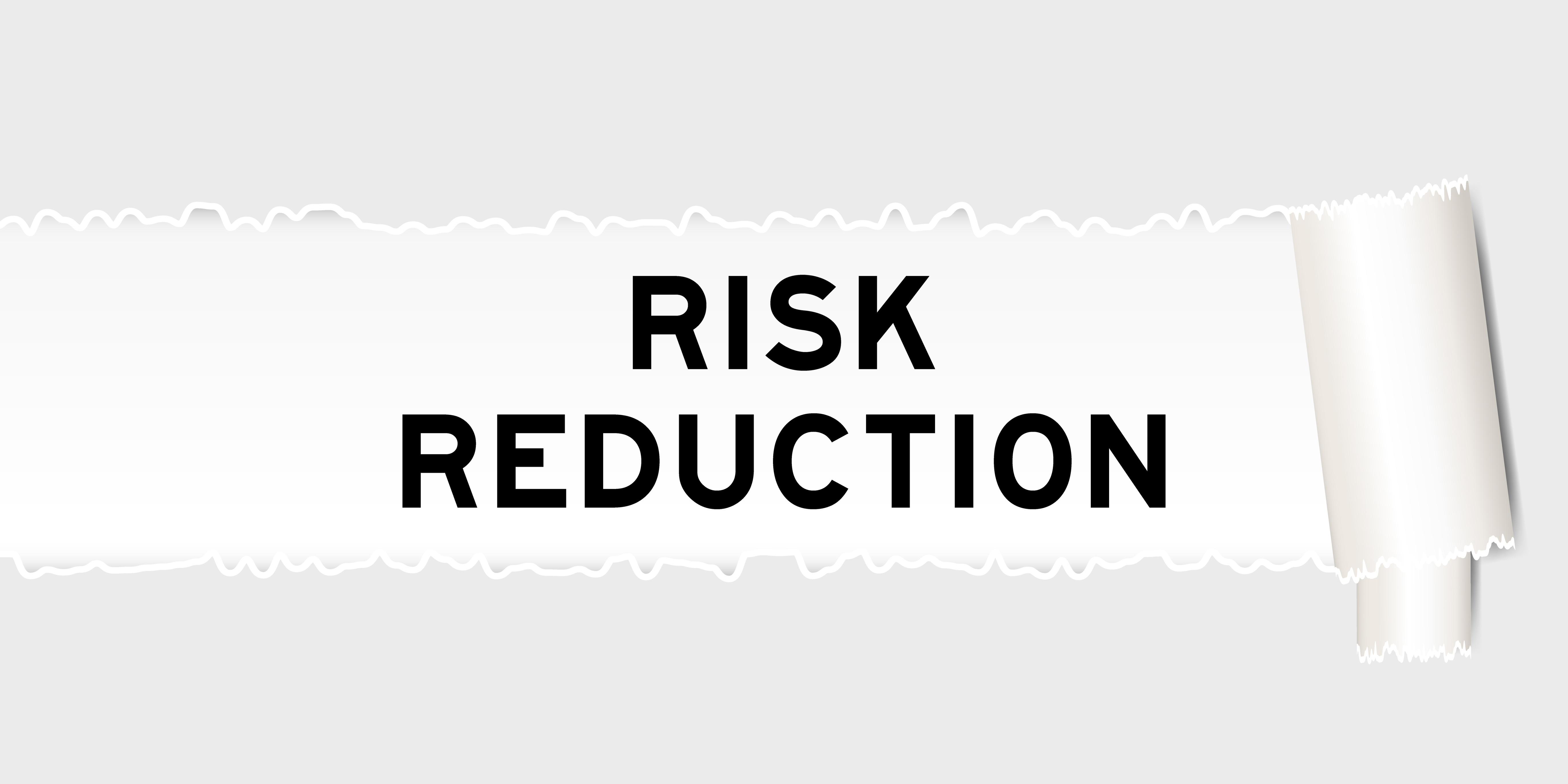 A torn paper banner with the words ‘Risk Reduction,’ emphasizing strategies or actions taken to minimize risks in business or investments.